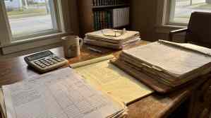 Estate Inventory Worksheet, calculator, legal binders, and handwritten notes on attorney desk